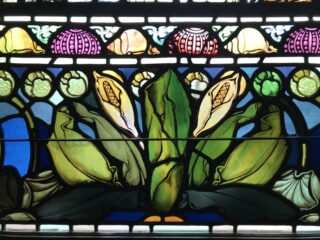 Stained glass window featuring skunk cabbage detail from 1901.