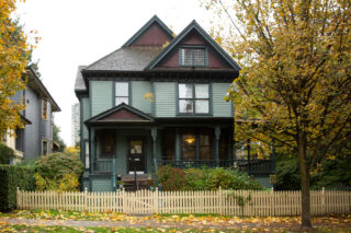 A well-kept 2 1/2 storey Victorian home found in the Mole Hill neighbourhood. We see a box-like design asymmetrical home, with a covered half-porch to the entrance supported by ornamental turned columns. This house is pampered with fishscale shingles on all 3 of its visible front-gables (one of which bears a dormer window). You can find the elaborate fretwork brackets on the porch and undereaves of this house. Also characteristic of a Victorian home is its wooden door with a glass panel.