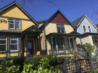 Three heritage homes painted in historically appropriate colours.