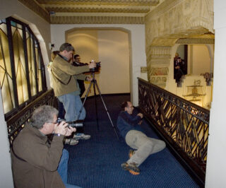 Several people taking photographs of the interior of an Art Decor heritage building.